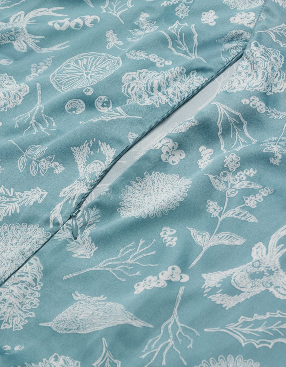 Cozy Earth Bamboo Duvet Cover in teal with a zipper closure, featuring a white line-art print of botanical elements and animals.