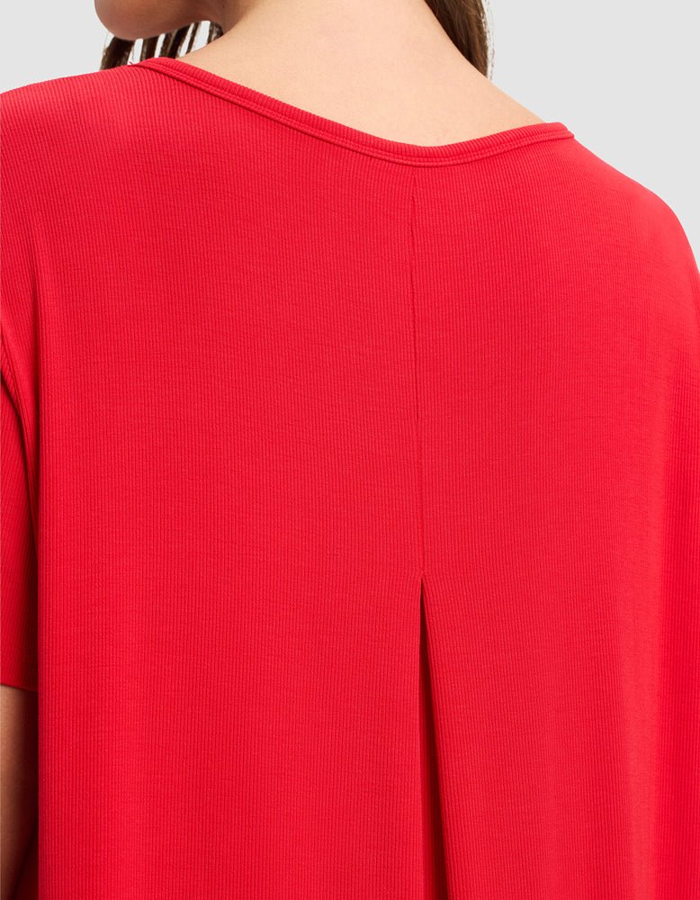 A close-up of a person wearing the Cozy Earth Women’s Bamboo Rib-Knit Boyfriend Sleep Dress, highlighting the back neckline, center pleat detail, and texture of the soft rib-knit fabric.