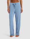 A person wears Cozy Earth's Women's Bamboo Stretch-Knit Pant—loose-fitting, light blue and white striped with a drawstring waist—standing barefoot against a plain white background.|Color:Sailor Mini Stripe