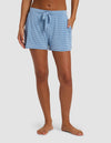 A person models the lower half of their body in Cozy Earth's Women's Bamboo Stretch-Knit Shorts, featuring light blue and white stripes and a drawstring waistband, standing barefoot against a plain background.|Color:Sailor Mini Stripe