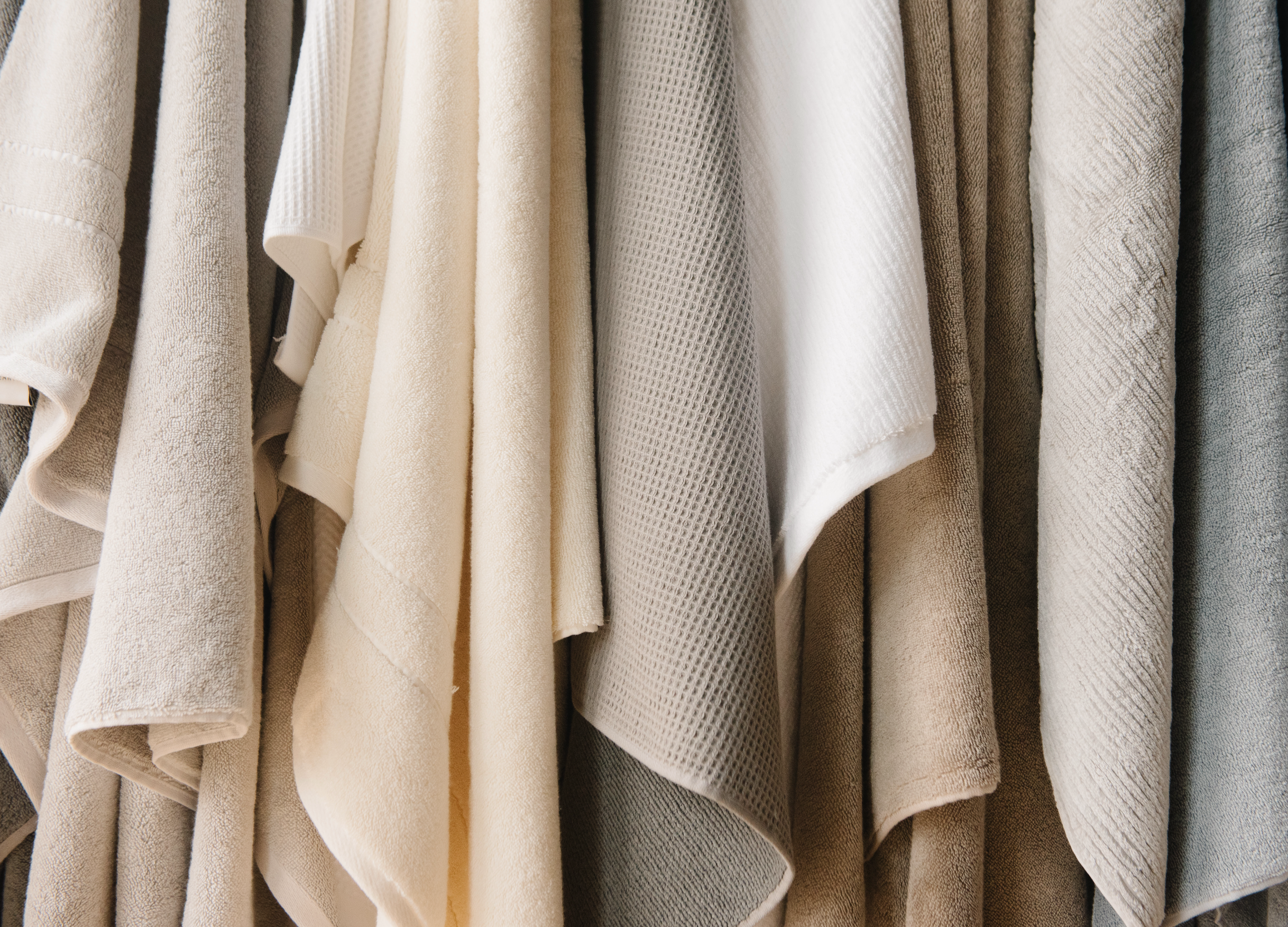 Close-up of an assortment of Cozy Earth towels in various colors and textured fabrics