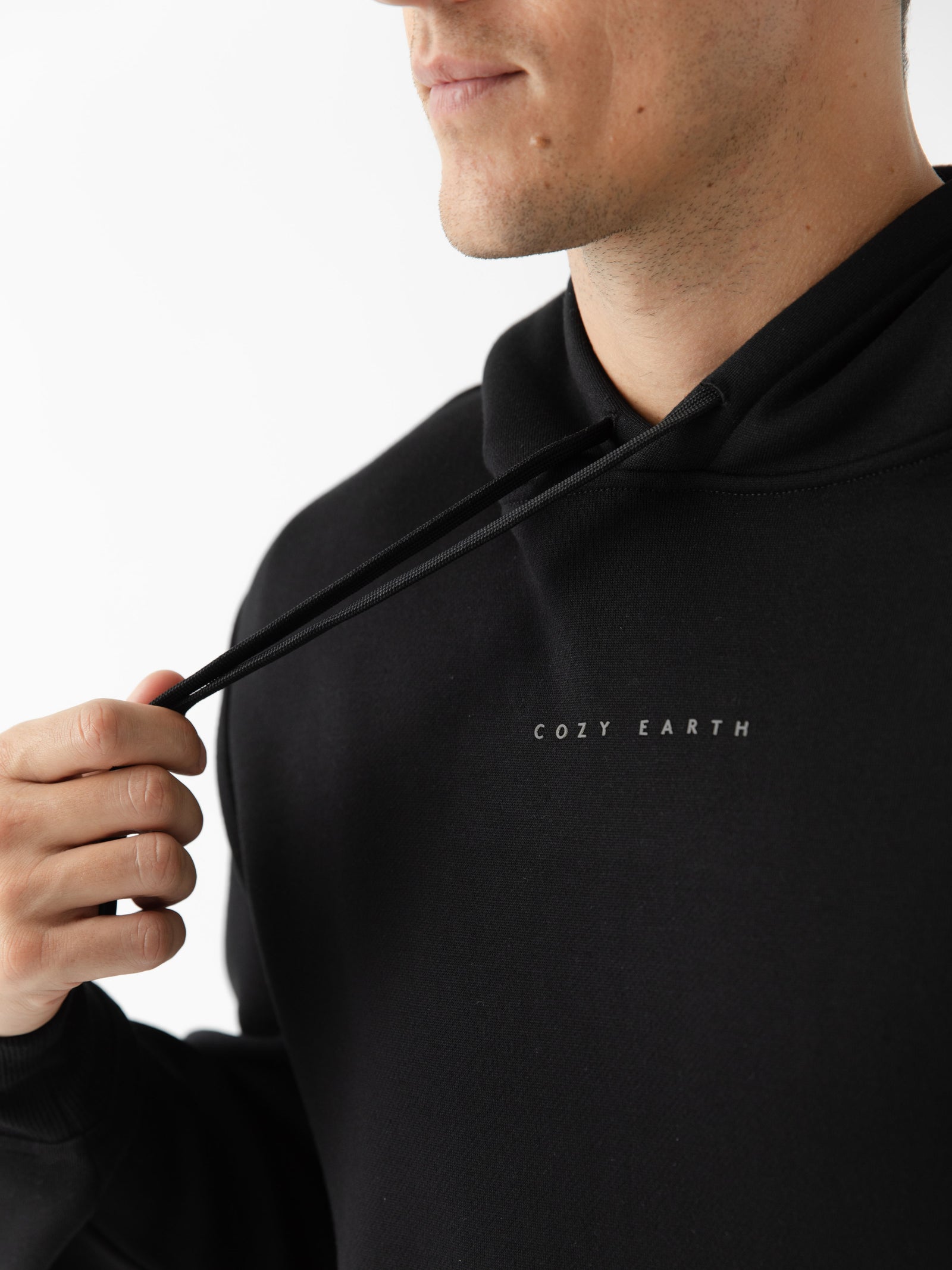 Close up of man wearing black cityscape hoodie with white background 