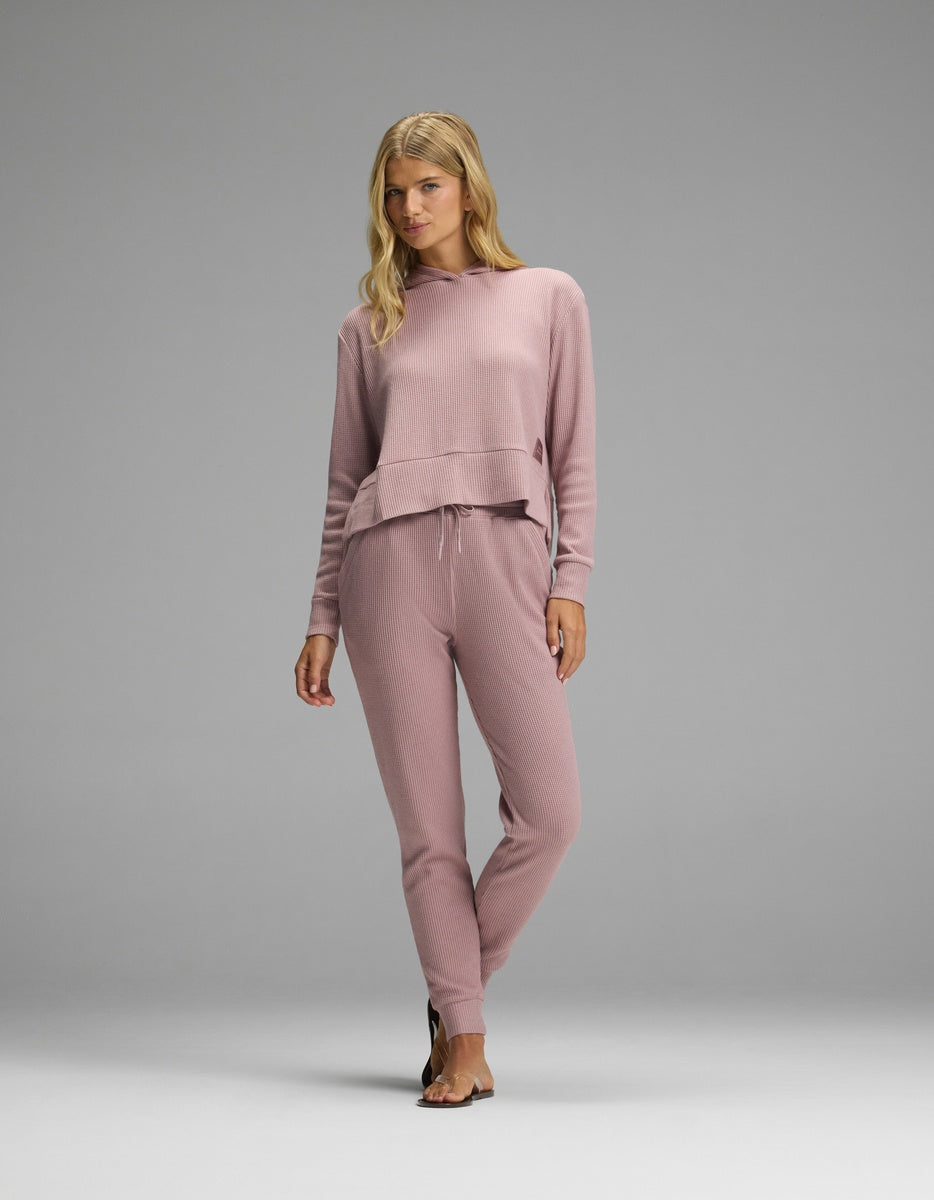 A woman wearing a mauve Cozy Earth Women’s Blake Waffle Hoodie & Jogger Set, consisting of a hooded long-sleeve top and slim-fit joggers.|Color:Viola