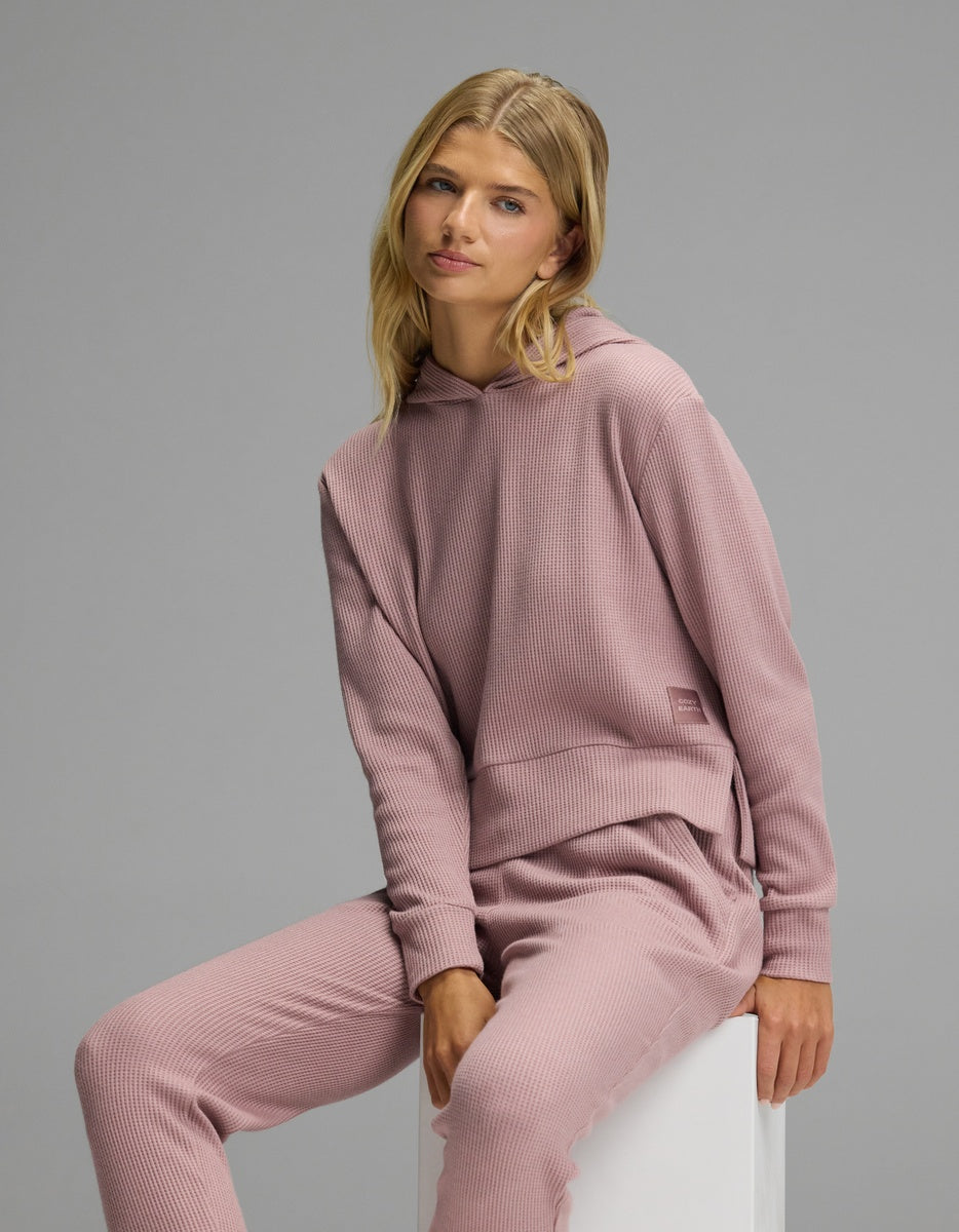 A person wearing a dusty pink Women’s Blake Waffle Hoodie & Jogger Set featuring a waffle-knit hoodie and matching jogger pants.