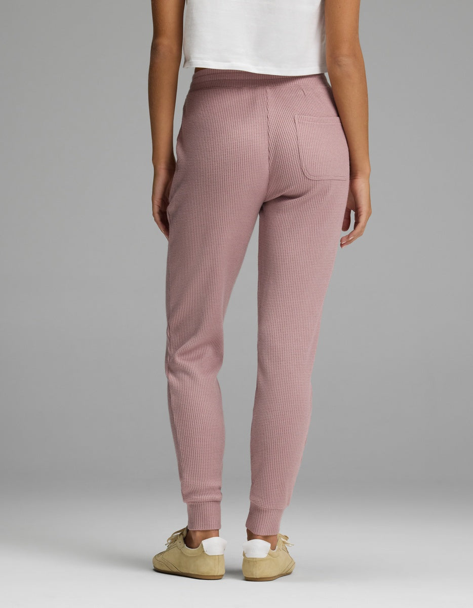 Back view of a person wearing mauve Women’s Blake Waffle Jogger pants featuring a back pocket and cuffed ankles.