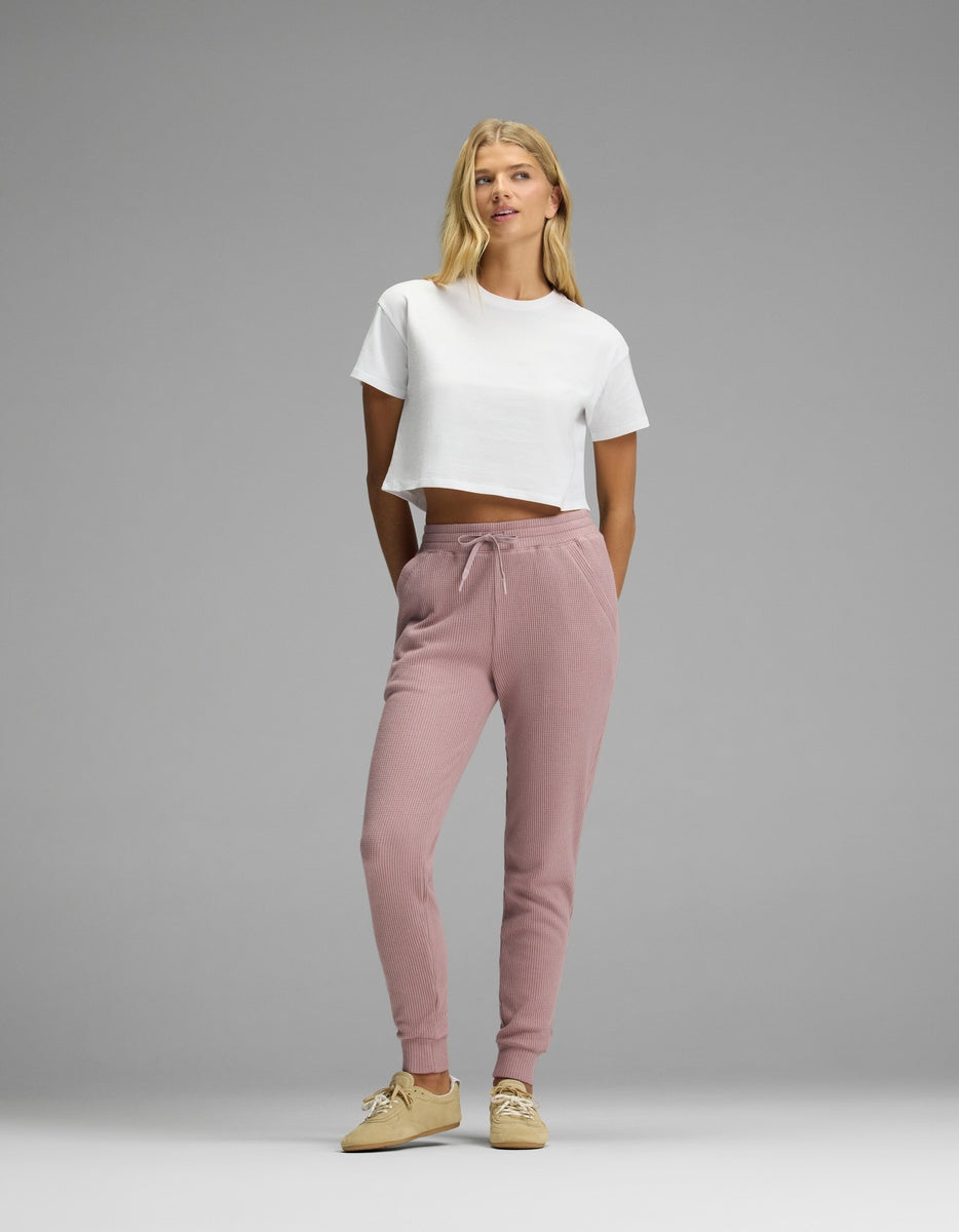A woman wearing a white cropped t-shirt and mauve Women’s Blake Waffle Jogger pants with a drawstring waist.