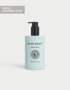 A light blue bottle of Cozy Earth Body Serum, 207 ml (7 fl oz), with a black pump top is displayed against a plain light background. A corner label states "NEWLY REFORMULATED.