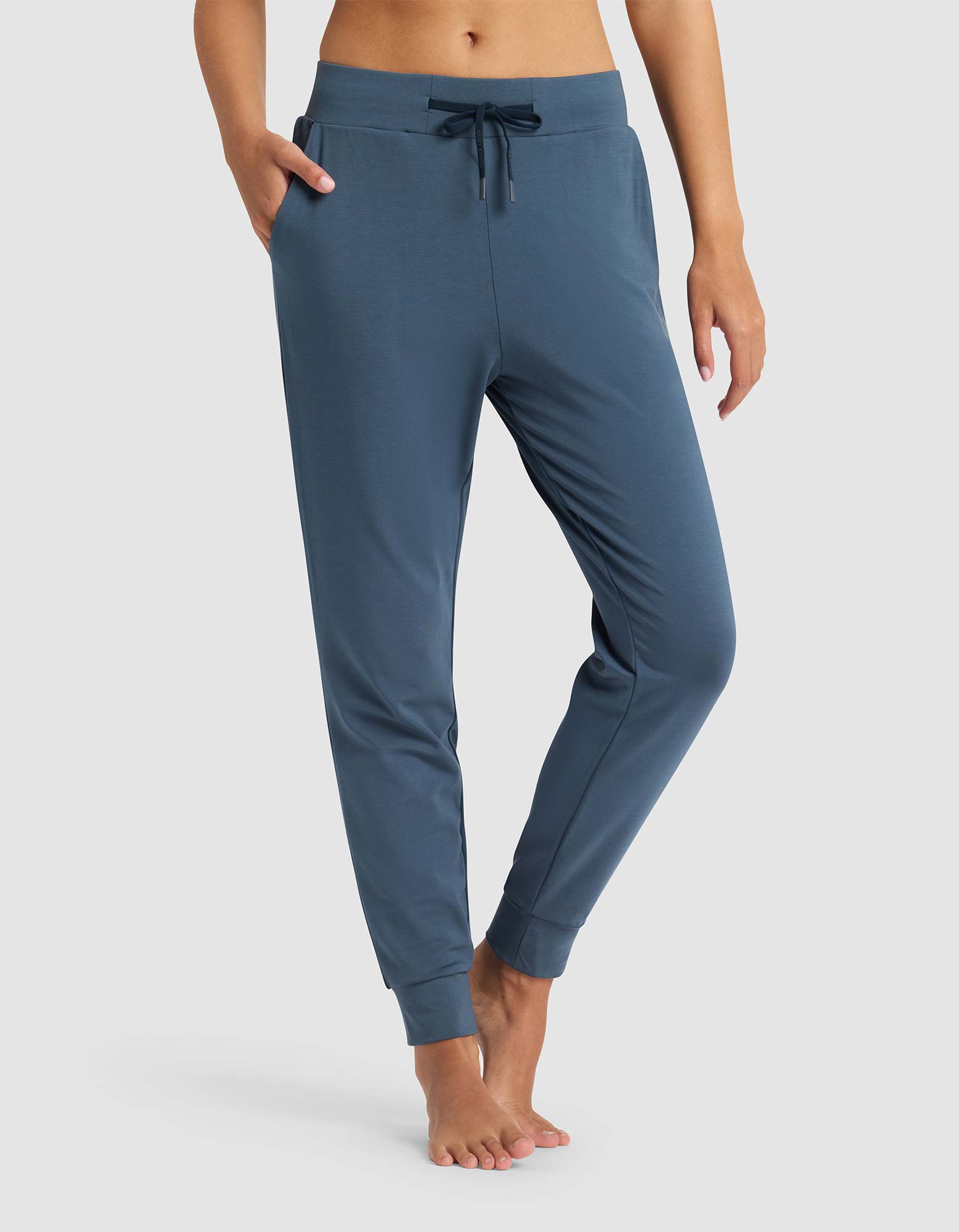 Blue jogger pants worn by a person on a white background 