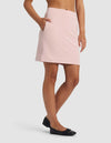 A person wearing the Cozy Earth Women's Brushed Bamboo Skirt in light pink with pockets and black flats stands against a plain white background.