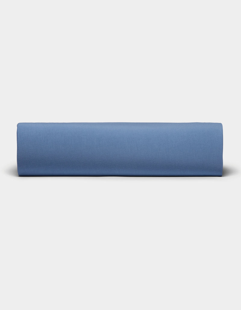 A neatly folded Bamboo Jersey Sheet Set by Cozy Earth is displayed against a plain, light gray background.
