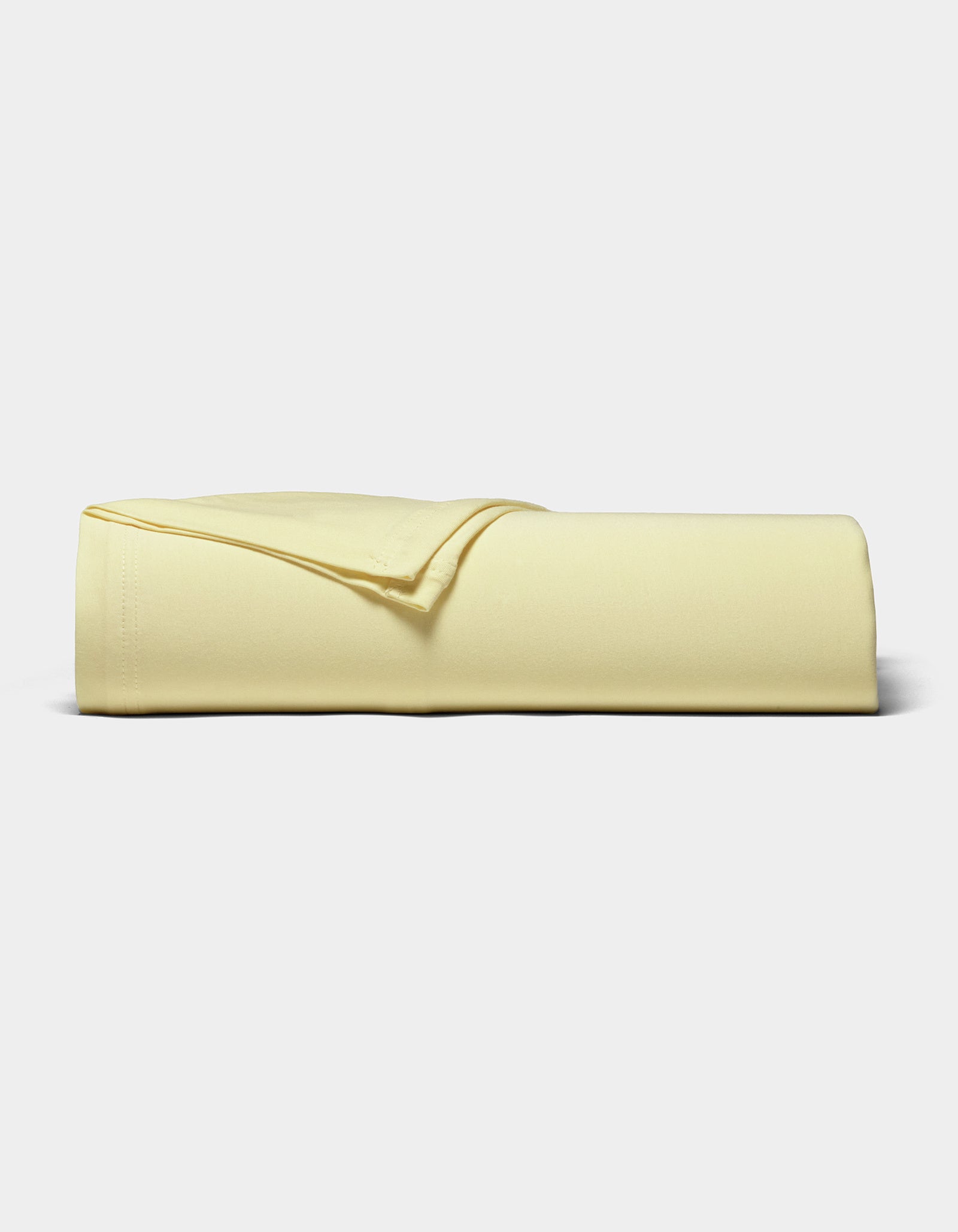 The Cozy Earth Bamboo Jersey Sheet Set, neatly folded in pale yellow, is displayed against a plain white background.