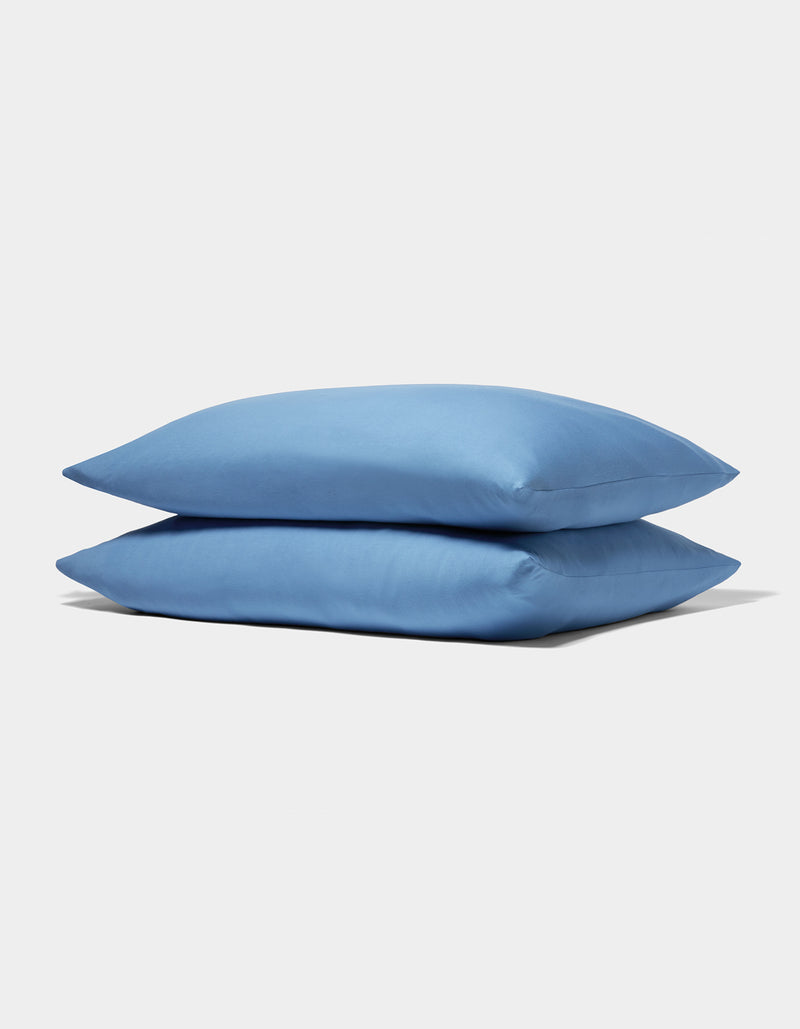 Two neatly stacked Cozy Earth Bamboo Jersey Pillowcases in light blue are displayed on a plain white background.