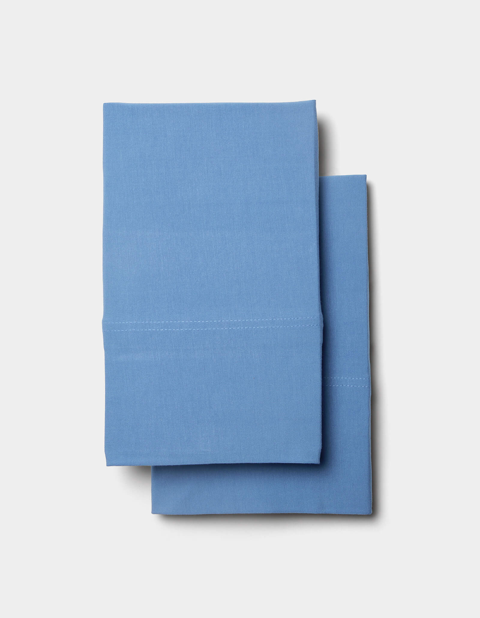 Two neatly folded Cozy Earth Bamboo Jersey Pillowcases stacked on top of each other against a light gray background.