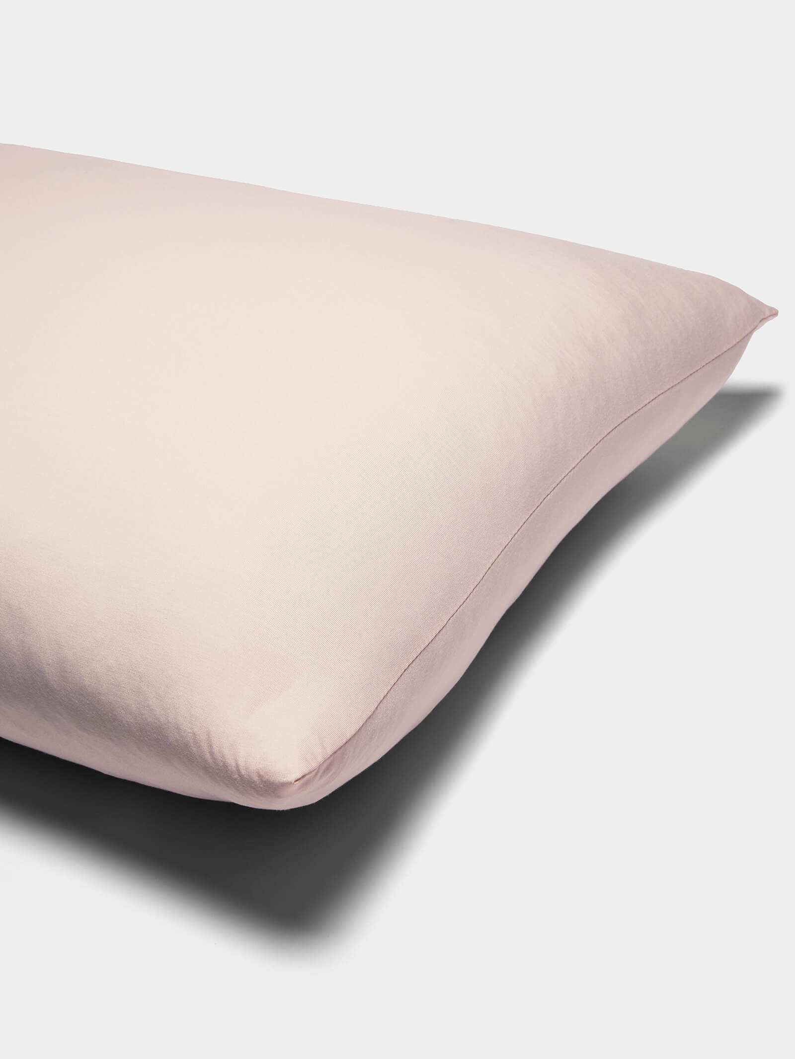 A close-up of Cozy Earth Bamboo Jersey Pillowcases in pale pink with a smooth, soft fabric cover, shown against a plain white background.