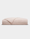 The Cozy Earth Bamboo Jersey Quilt, shown folded in blush-pink with a quilted grid pattern, is displayed against a plain white background.|Color:Petal