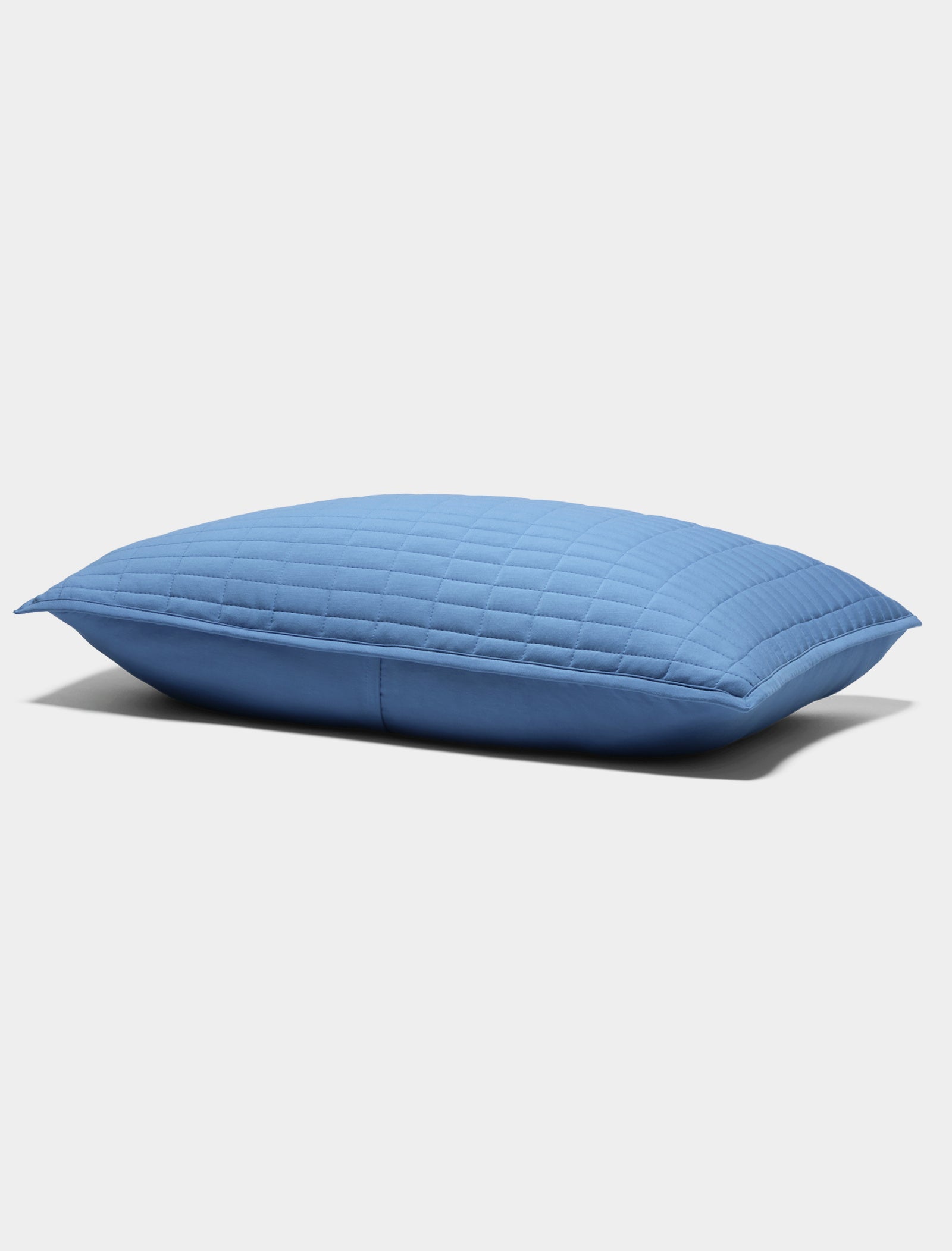 The Bamboo Jersey Quilted Sham by Cozy Earth is a blue, rectangular pillow with a quilted pattern, displayed on a plain white background.