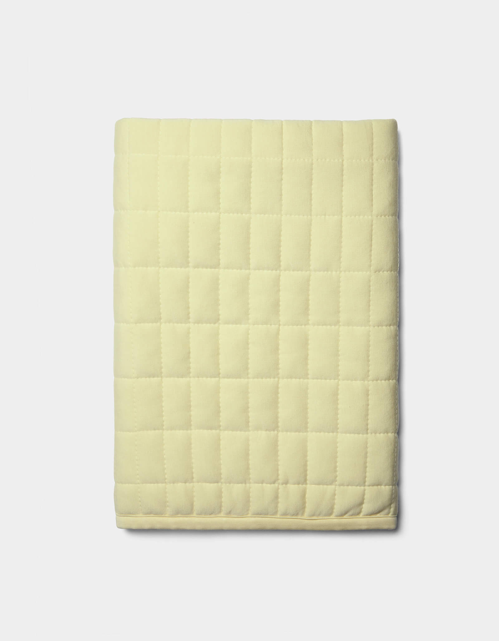 The Cozy Earth Bamboo Jersey Quilted Shams in light yellow, featuring a square grid pattern, are neatly displayed against a plain white background.