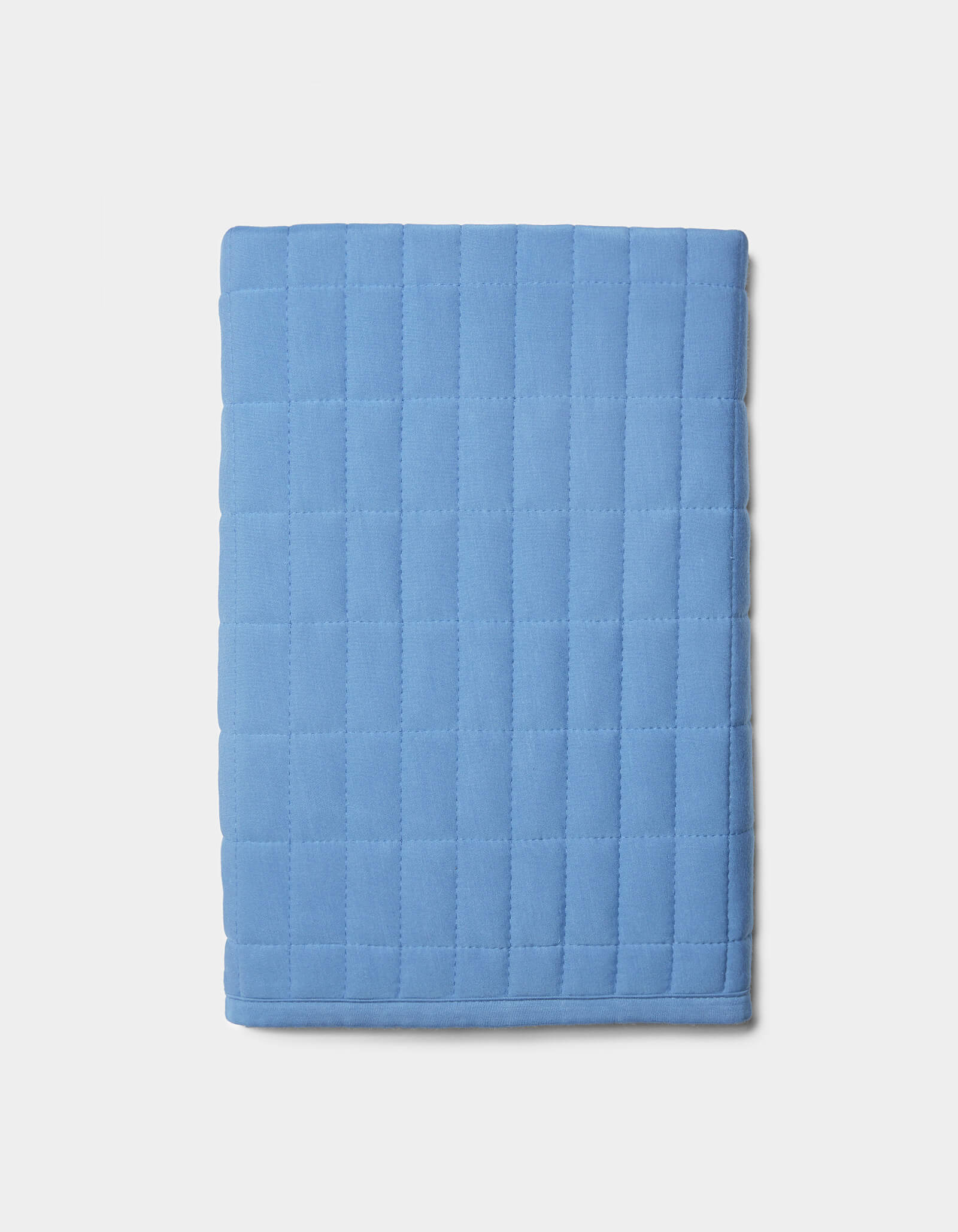 The Cozy Earth Bamboo Jersey Quilted Shams, in light blue with a square quilted pattern, are displayed folded on a plain white background.