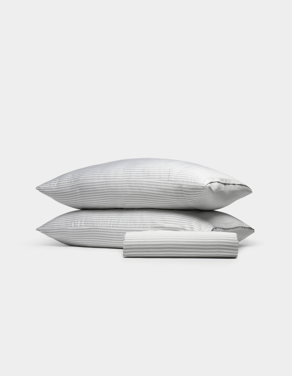 Two Classic Stripe in Dew pillows from the Cozy Earth Bamboo Bedding Basic Bundle are stacked on top of each other, with a neatly folded matching pillowcase placed in front, all set against a plain white background.