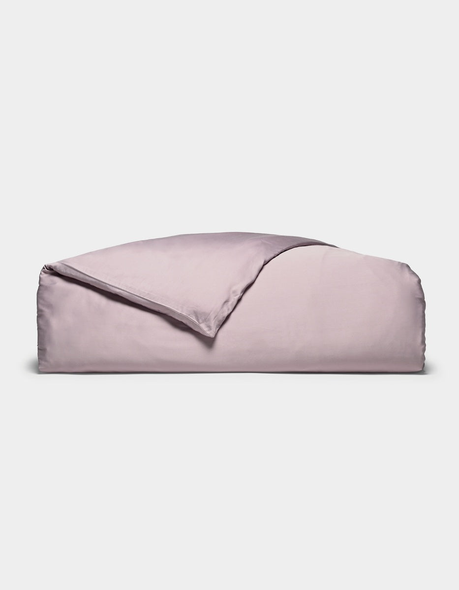 A neatly folded Cozy Earth Bamboo Duvet Cover in lavender, with one corner turned back, displayed against a plain white background.