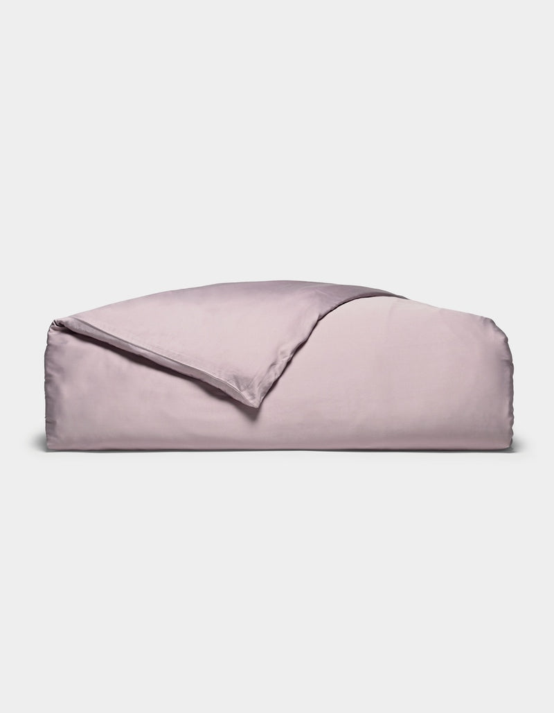 A neatly folded Cozy Earth Bamboo Duvet Cover in lavender, with one corner turned back, displayed against a plain white background.