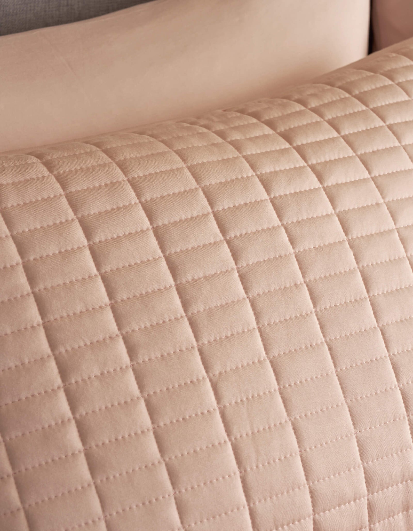 Close-up of Cozy Earth Bamboo Jersey Quilted Shams, showing a beige quilted fabric with a grid pattern of stitched lines. The texture and stitching of this soft, elegant sham are clearly visible.