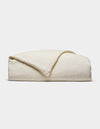 The Cozy Earth Linen Duvet Cover, in an off-white shade, is neatly folded against a white background. Its soft, slightly textured fabric is visible with one corner casually turned over.|Color:Flax