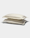 Two cream-colored Cozy Earth Linen Shams with slightly ruffled edges are stacked on top of each other against a plain white background.|Color:Flax