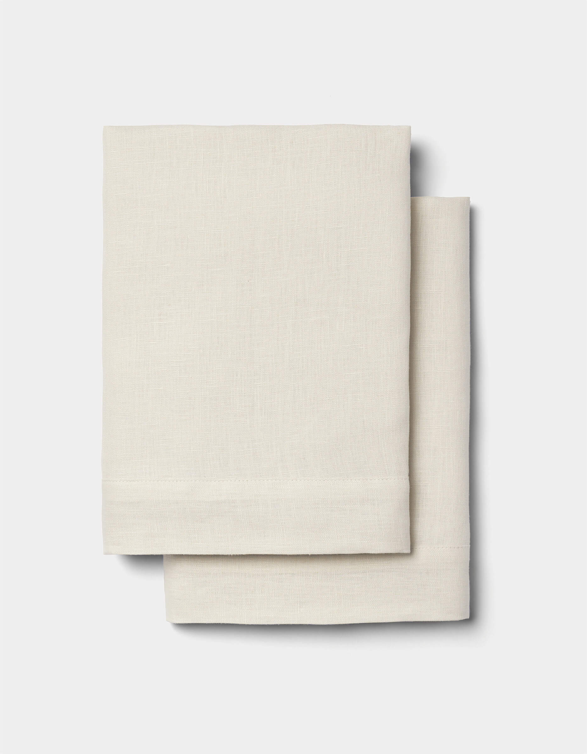 Two neatly folded Cozy Earth Linen Shams in light beige are stacked together against a plain white background.