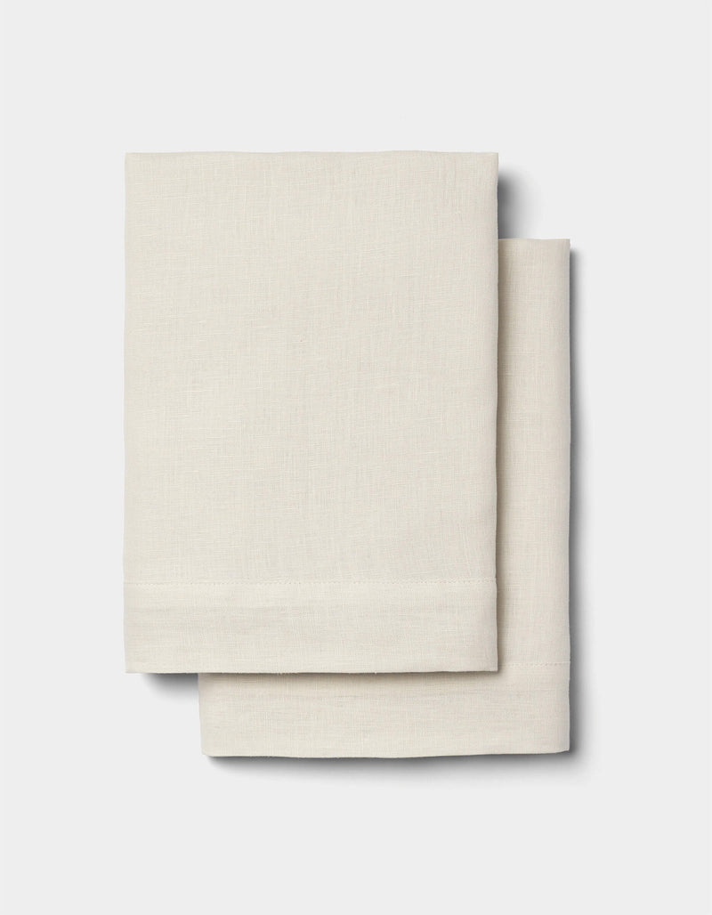 Two neatly folded Cozy Earth Linen Shams in light beige are stacked together against a plain white background.