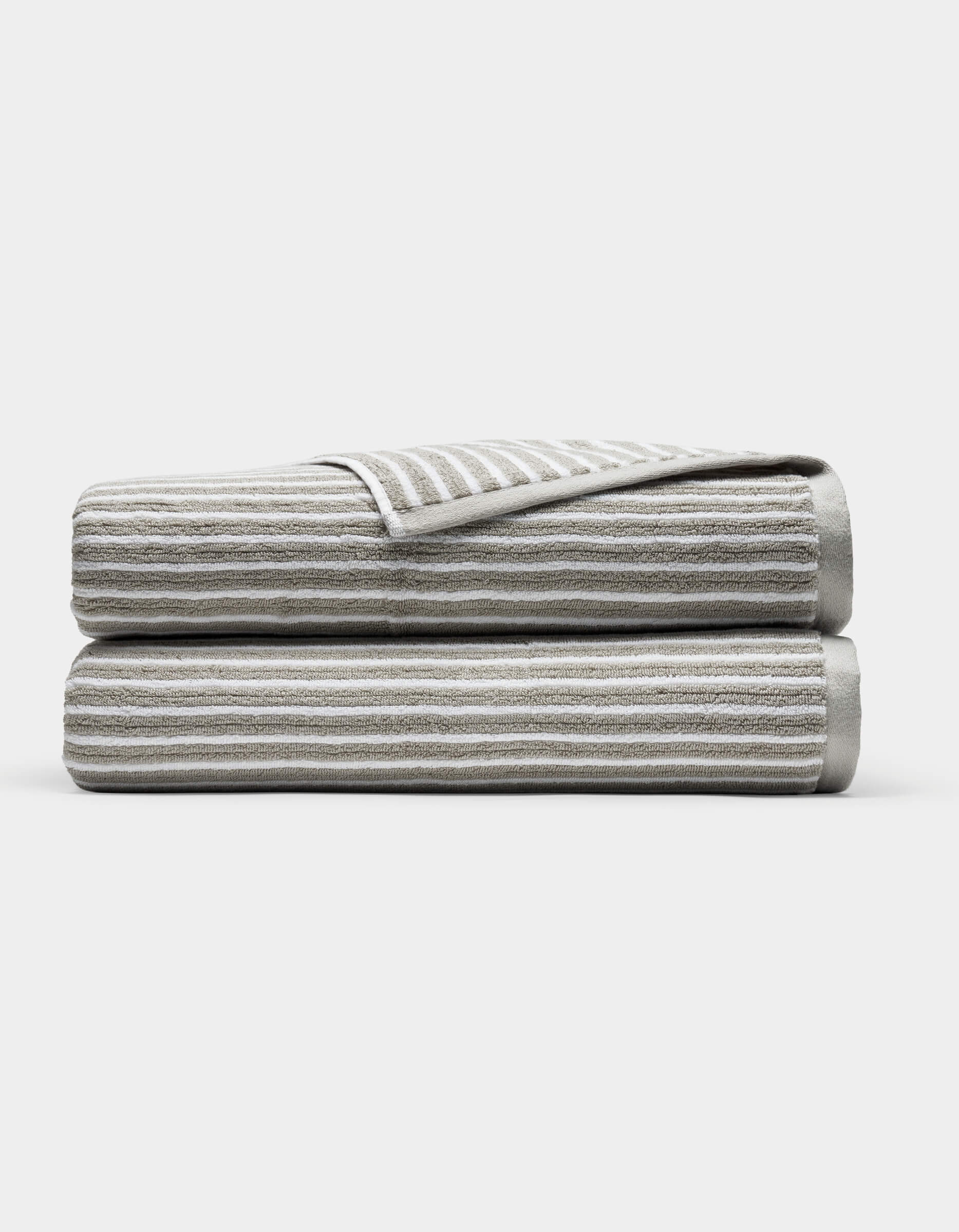 Two Cozy Earth Ribbed Terry Bath Sheets in gray and white stripes are folded and stacked on each other against a plain white background.