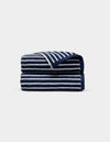 A Ribbed Terry Hand Towel by Cozy Earth, featuring horizontal navy blue and white stripes, is neatly folded against a plain light gray background.|Color:Obsidian Stripe