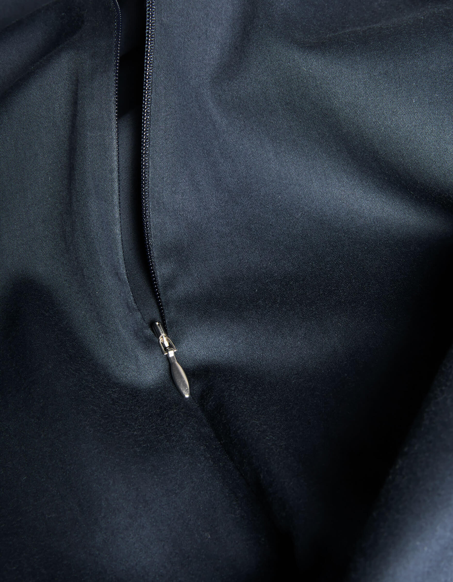 Close-up of Cozy Earth's Soft-Wash Cotton Duvet Cover featuring a partially opened zipper, highlighting the smooth texture and subtle sheen of the premium dark cotton fabric.