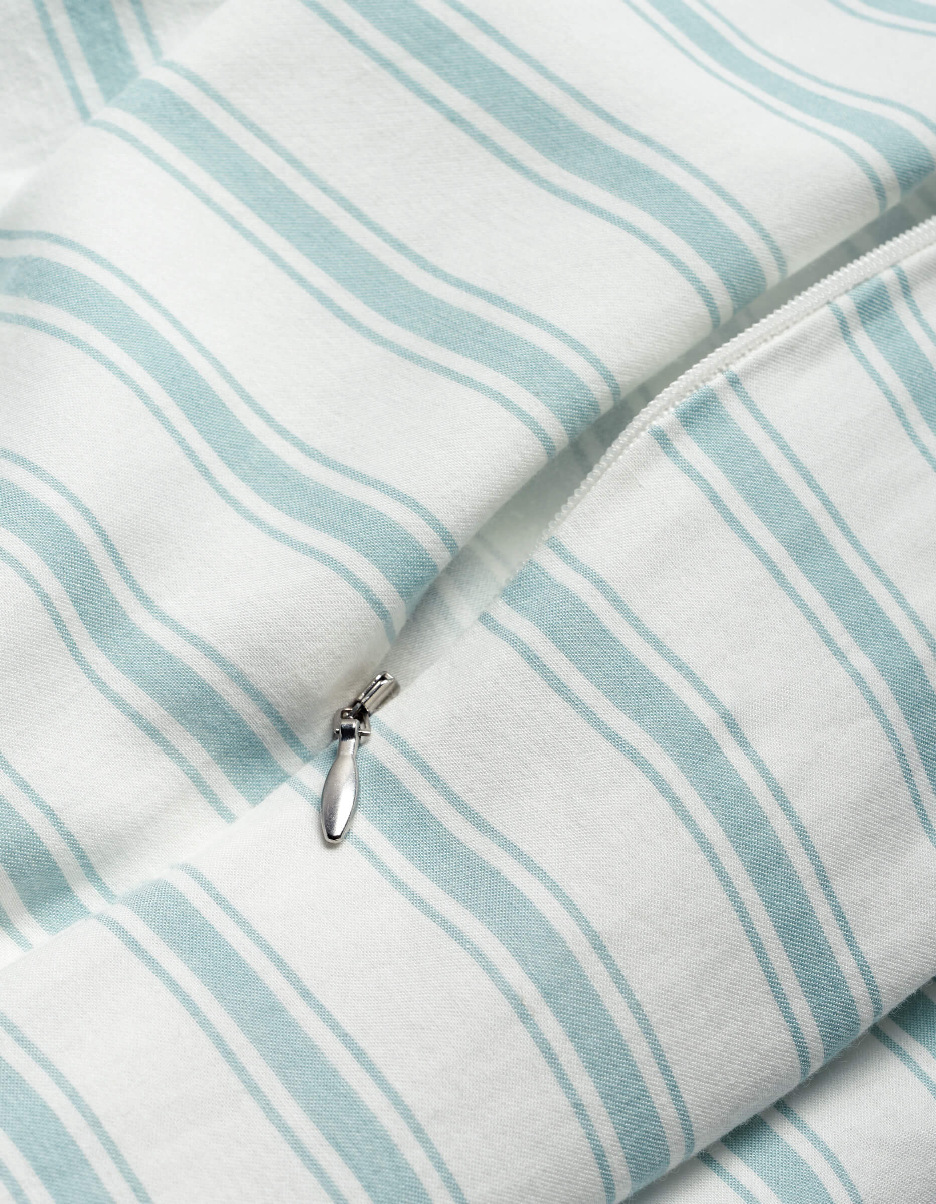 Close-up of the Cozy Earth Soft-Wash Cotton Duvet Cover in white with light blue stripes, highlighting a partially unzipped silver zipper.