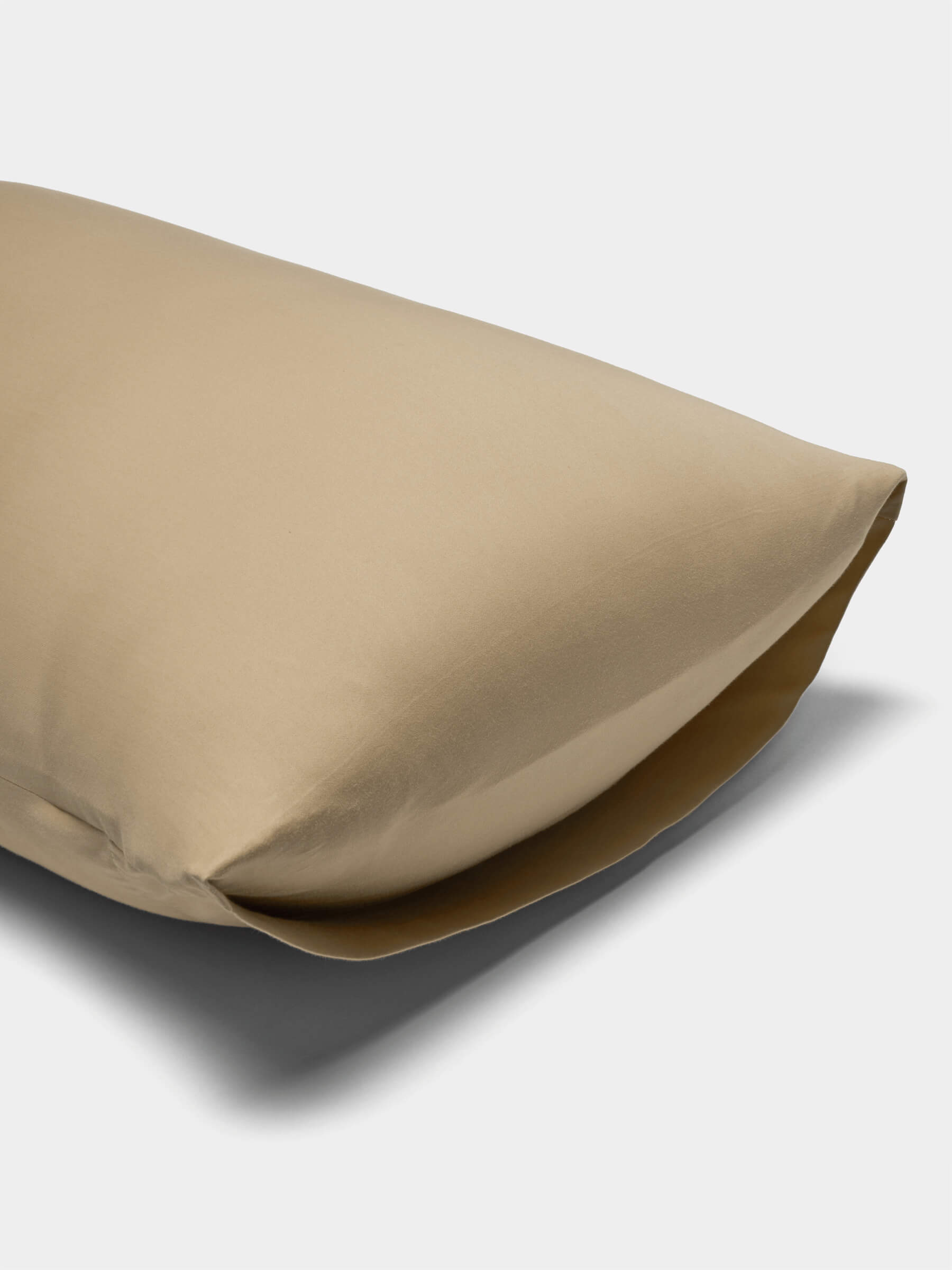 A Cozy Earth Soft-Wash Cotton Pillowcase in beige is displayed on a white background, shown slightly open at one end to reveal the pillow inside.