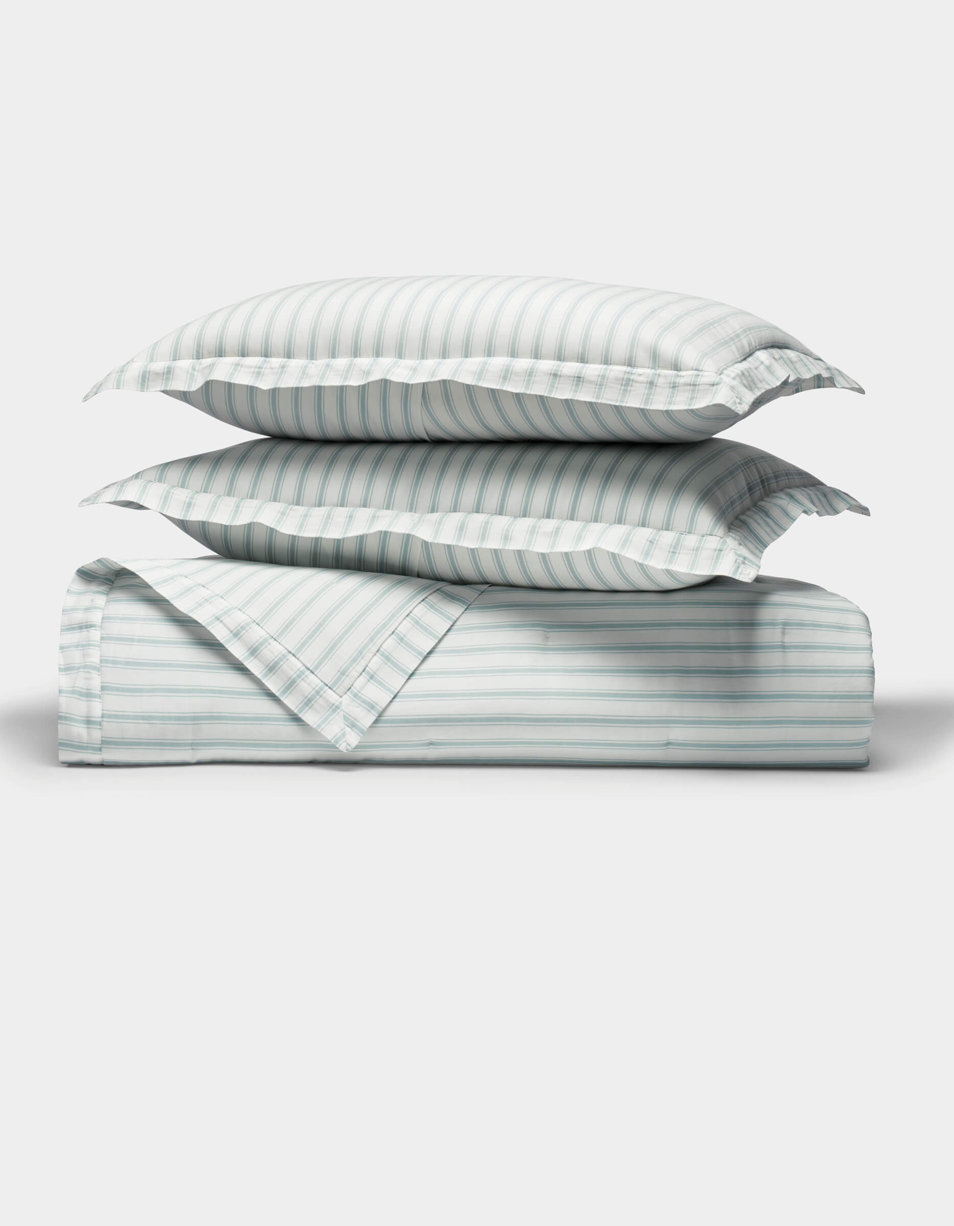 The Cozy Earth Soft-Wash Cotton Quilt Set, featuring two pillows and a folded quilt with light blue and white vertical stripes, is neatly arranged on a white background, highlighting its soft texture.|Color:River and Sea Salt Stripe