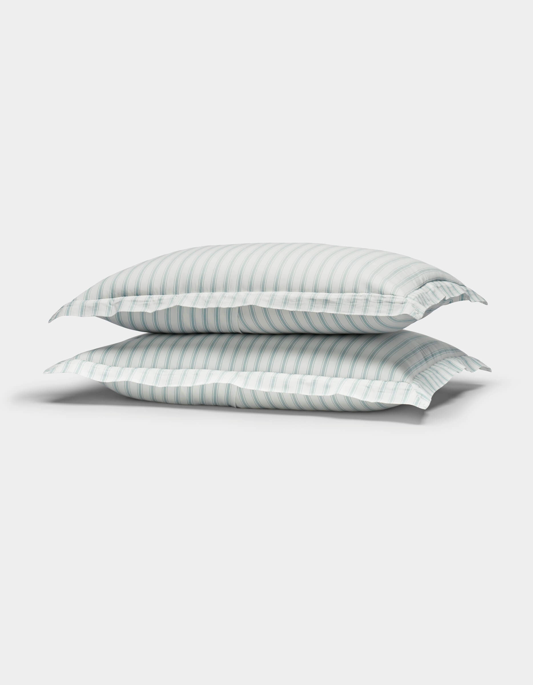Two Cozy Earth Soft-Wash Cotton Quilted Shams in white with light blue and gray stripes are stacked together against a plain white background.