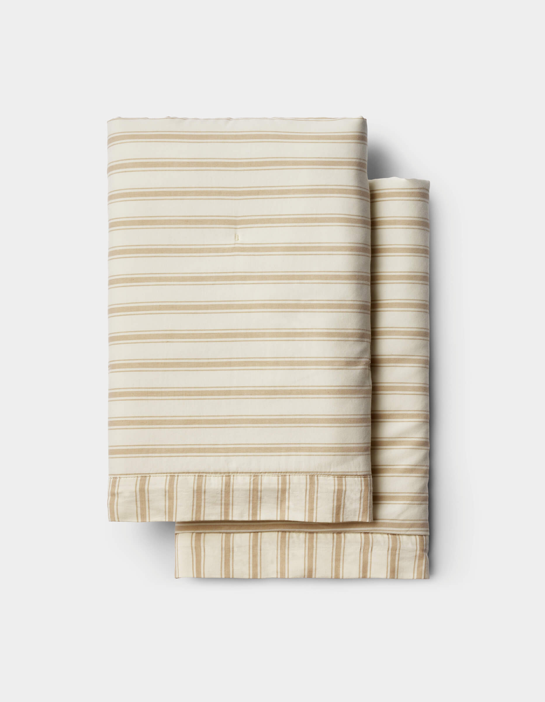 Cozy Earth Soft-Wash Cotton Quilted Shams in cream with horizontal beige stripes, folded and displayed on a white background.