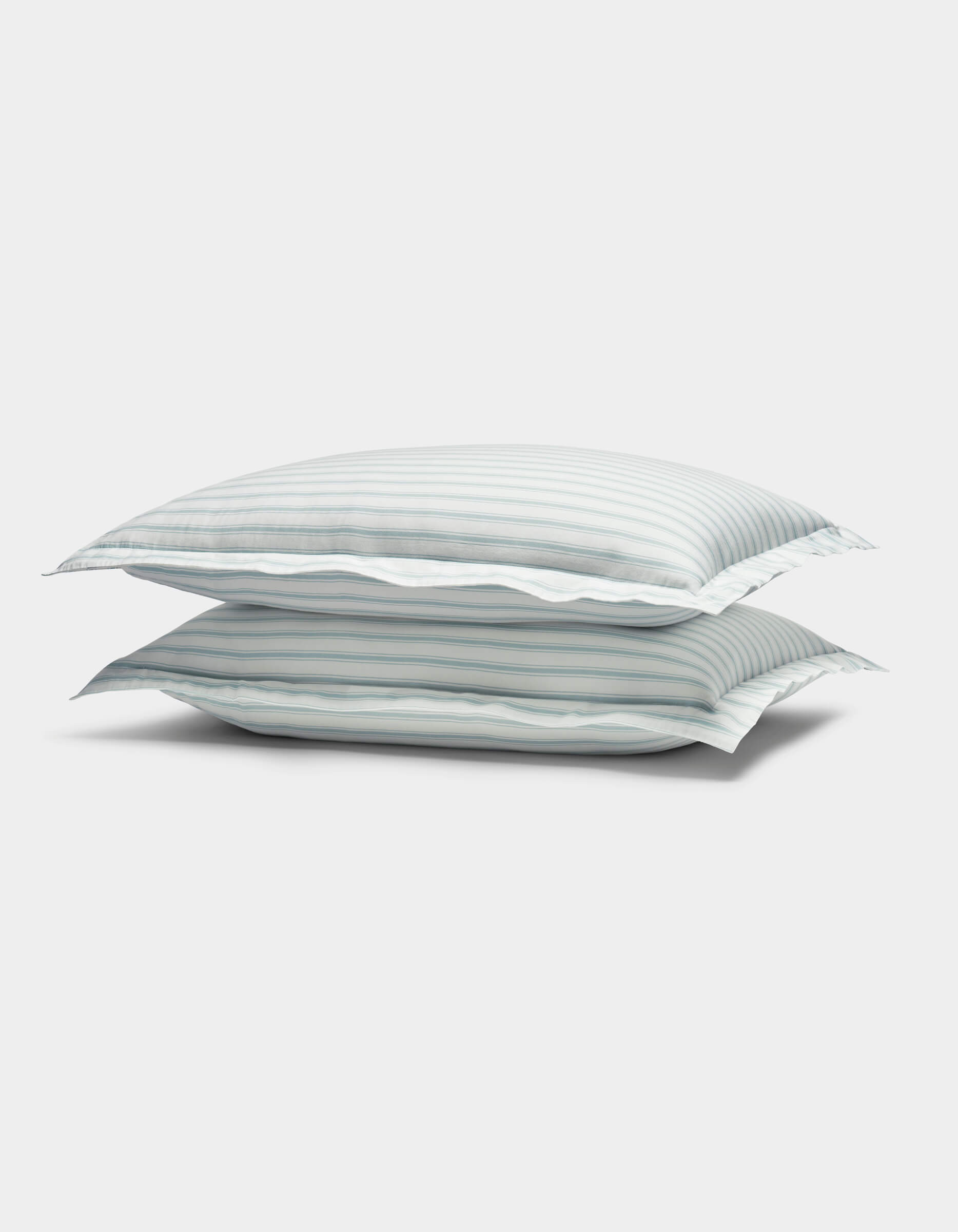 The image shows two Soft-Wash Cotton Shams by Cozy Earth, featuring light blue and white horizontal stripes, stacked against a plain white background.