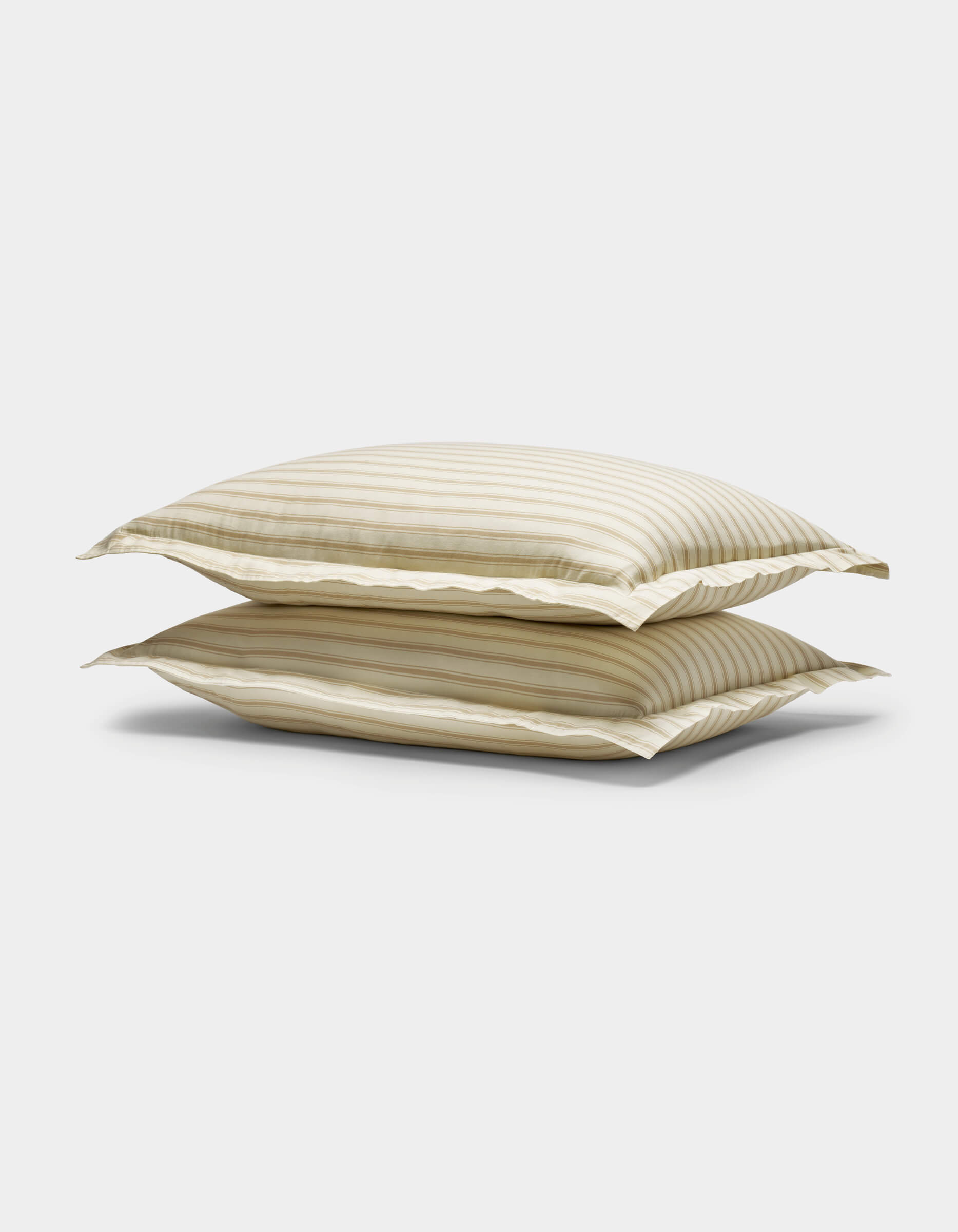 Two stacked Soft-Wash Cotton Shams by Cozy Earth, featuring beige and white stripes with a subtle sheen, displayed against a plain white background.