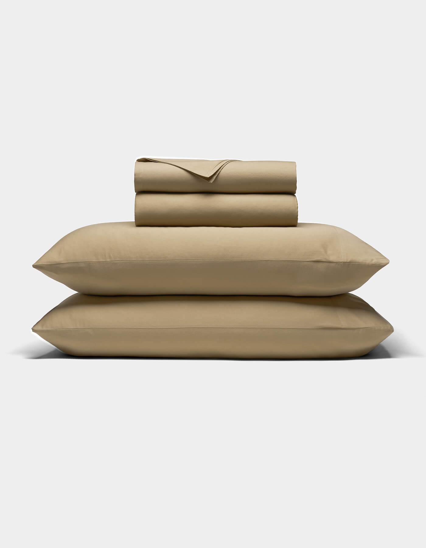 The Cozy Earth Soft-Wash Cotton Sheet Set, featuring two pillowcases, a flat sheet, and a fitted sheet in beige, is neatly folded and stacked on a light gray background.