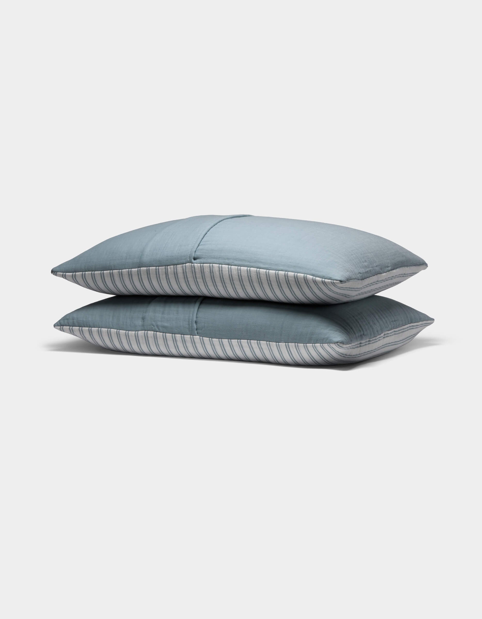 Two Waterfront Shams by Cozy Earth, featuring subtle blue stripes, are stacked neatly atop each other against a plain white background.