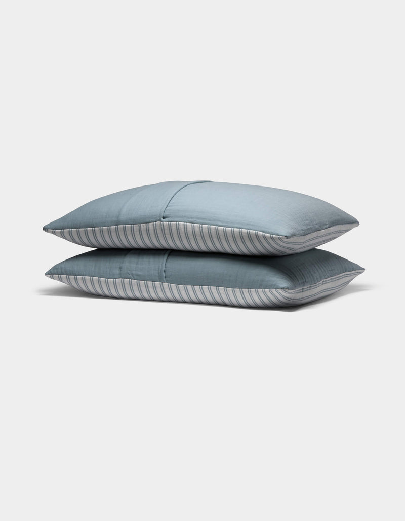 Two Waterfront Shams by Cozy Earth, featuring subtle blue stripes, are stacked neatly atop each other against a plain white background.