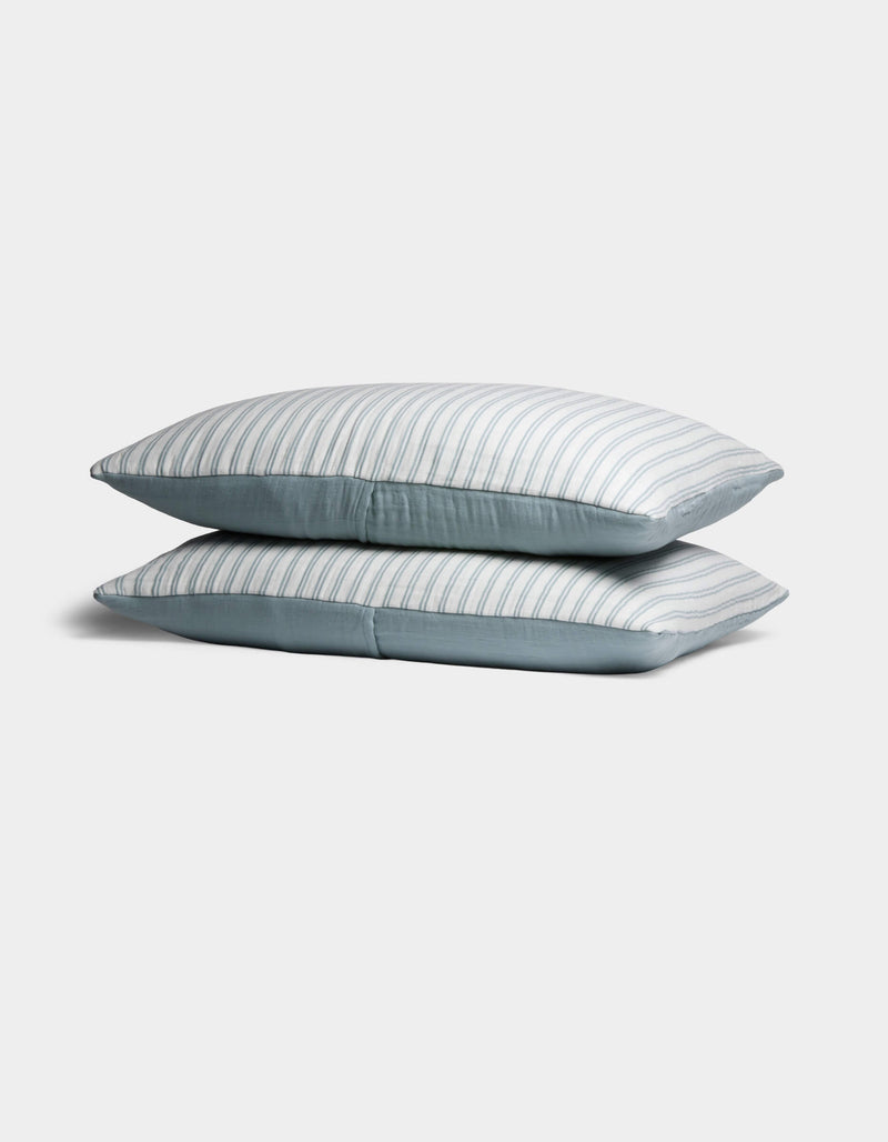 Two Cozy Earth Waterfront Shams are stacked neatly, featuring light blue and white stripes, against a plain white background.