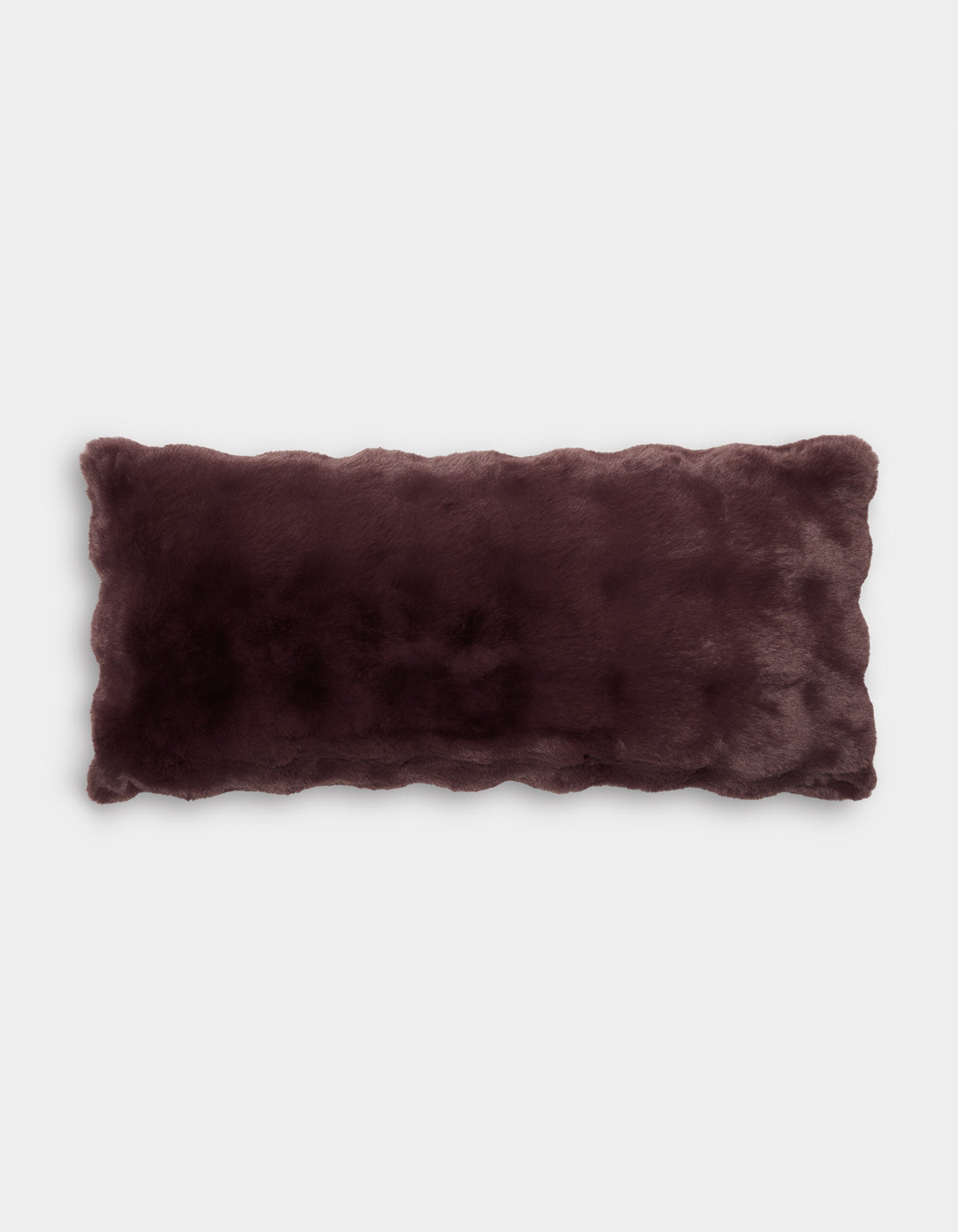 The Bubble Cuddle Pillow by Cozy Earth is a rectangular faux fur pillow in dark brown, featuring scalloped edges and displayed on a plain white background.