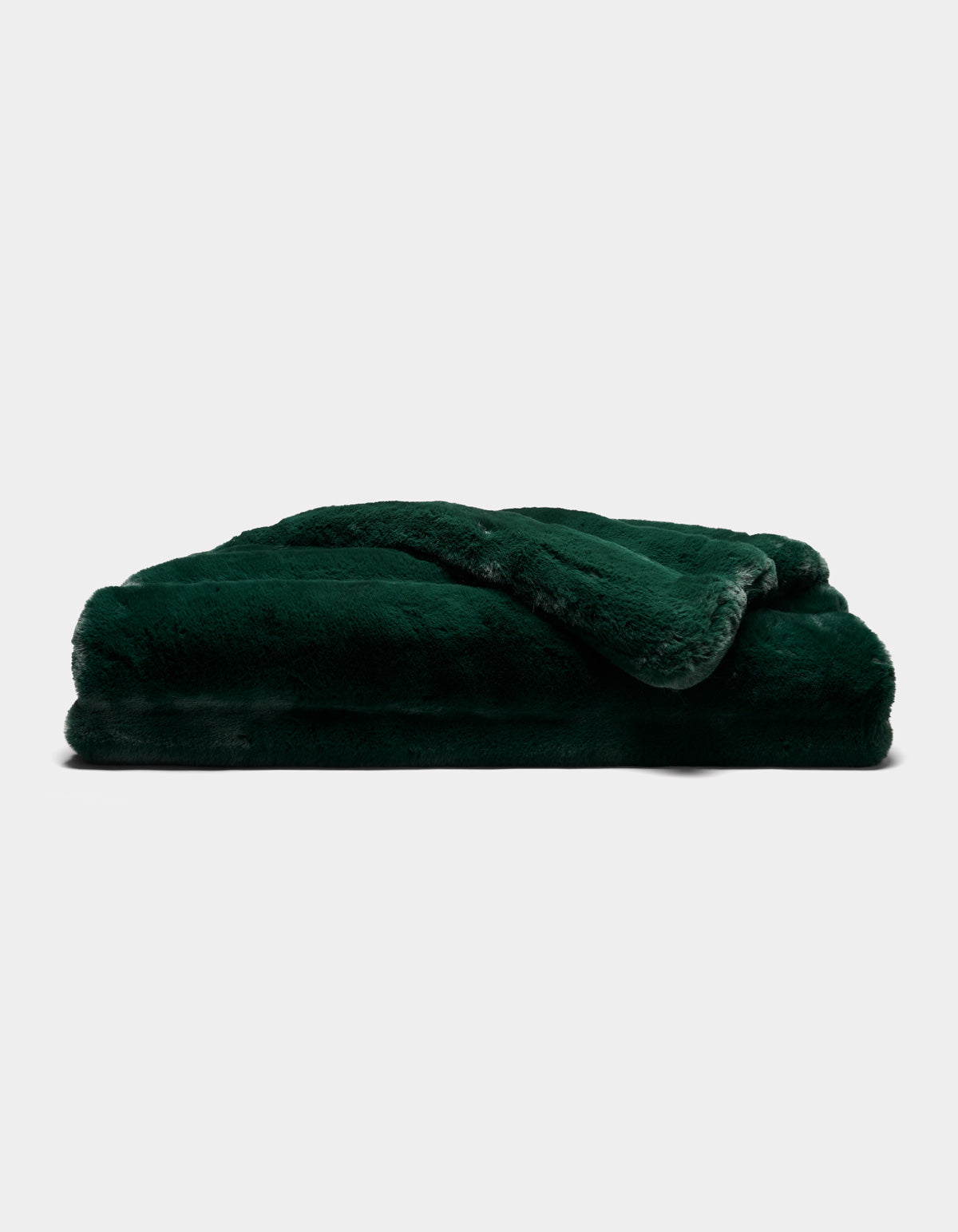 A Cozy Earth Channel Cuddle Blanket in dark green, featuring plush fur, is neatly folded and stacked against a plain white background.