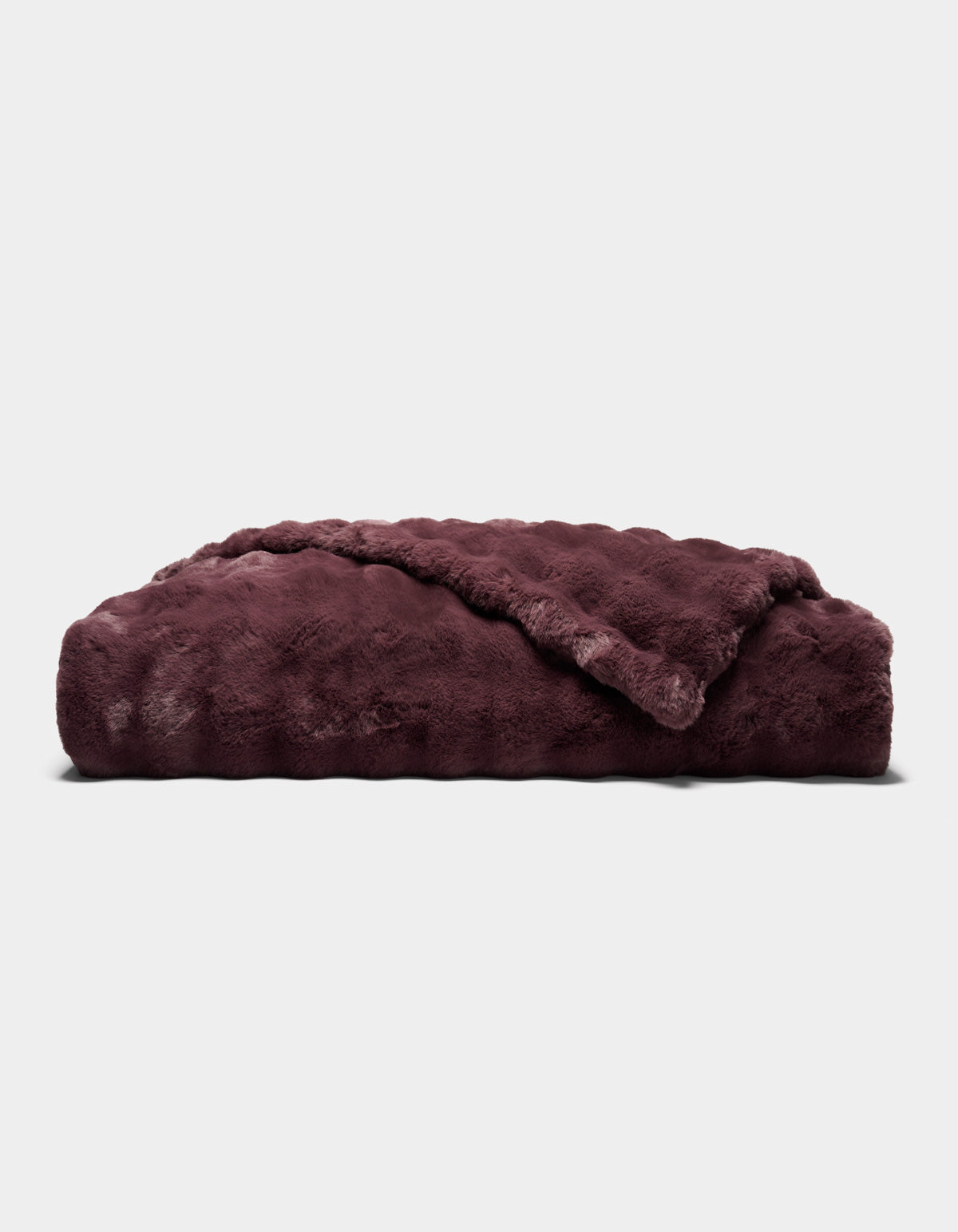 A folded, plush Bubble Cuddle Blanket by Cozy Earth in dark burgundy, featuring a soft, furry texture, displayed against a plain light gray background.