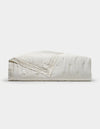 A folded Cozy Earth Bamboo Quilt in white, featuring a subtle floral pattern, displayed on a plain white background.|Color:Sonoma Floral in Vintage White