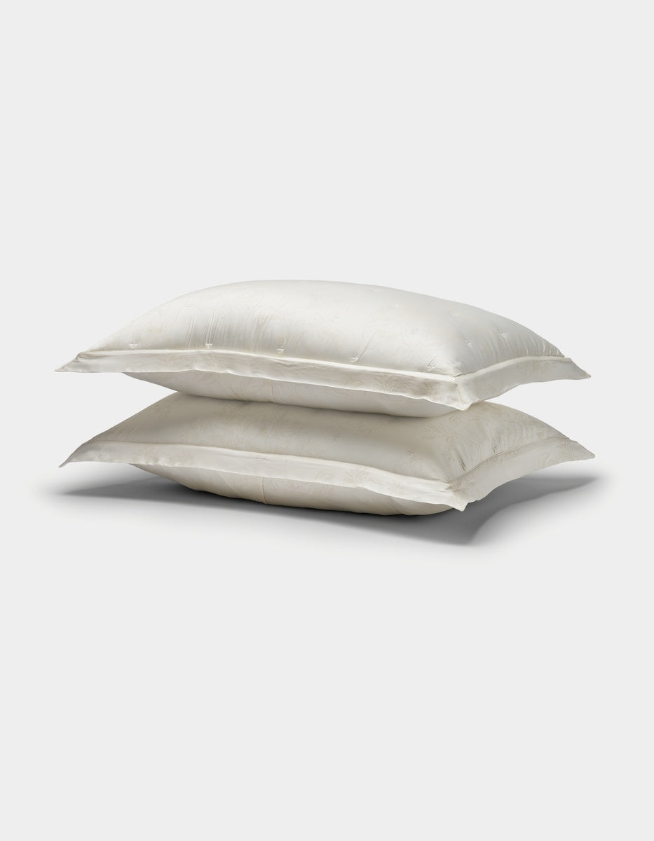 Two Cozy Earth Bamboo Quilted Shams in white, stacked on top of each other against a plain white background.