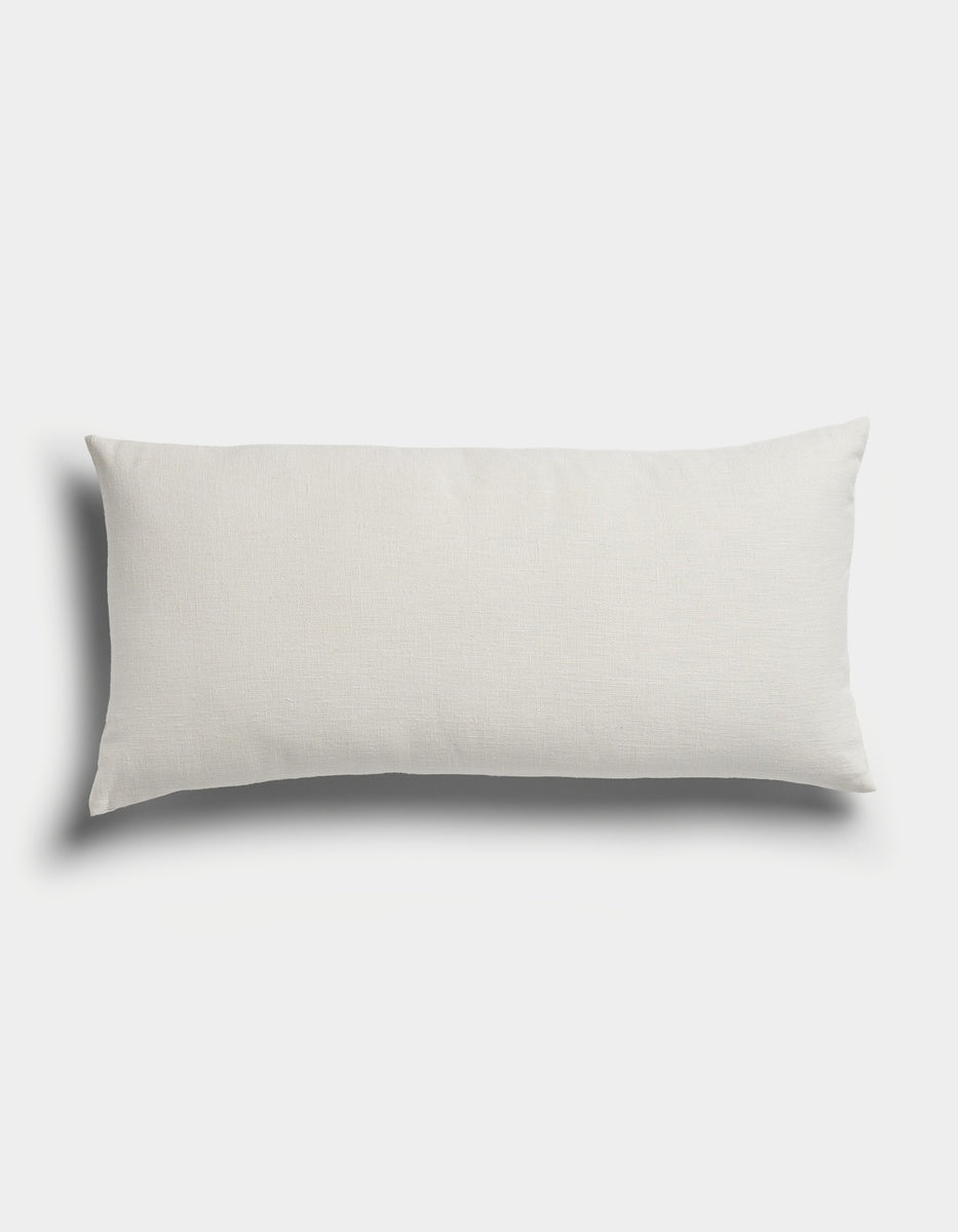 The Sonoma Throw Pillow by Cozy Earth, featuring a rectangular, white design, is displayed on a plain white background with soft shadows on the left and bottom sides.